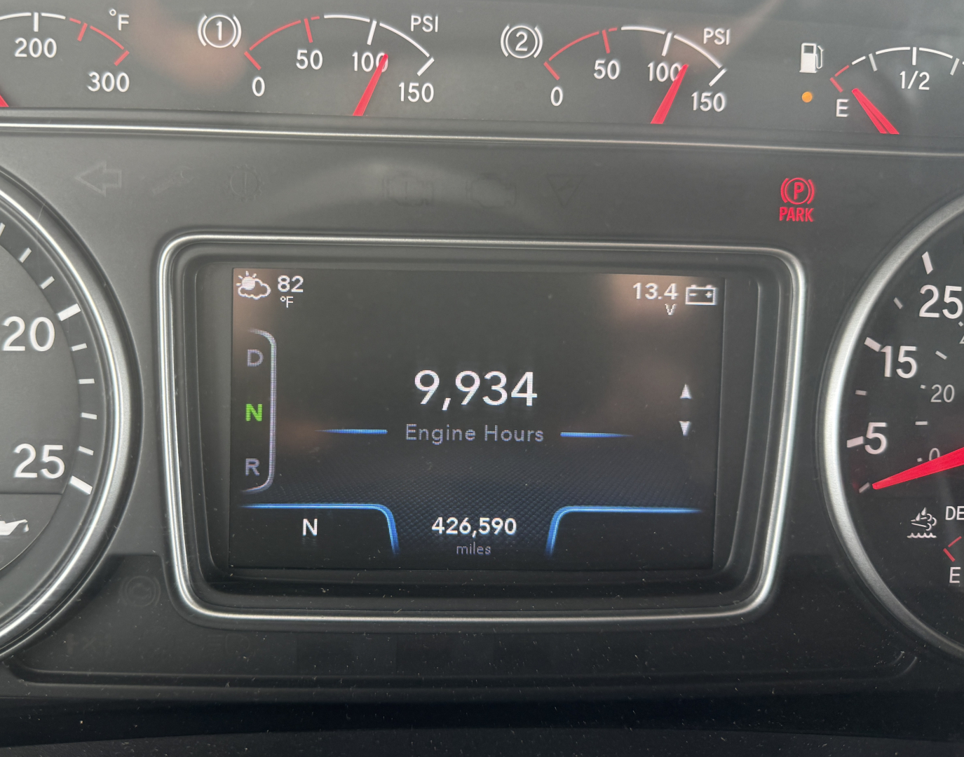 Dashboard center display showing engine hours 9,934 and N gear indicator with N 426,590 miles, 82°F outside, 13.4V, in International LT625 truck cockpit.