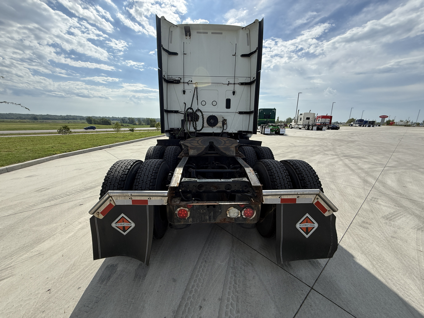 Rear view of a used 2022 International LT625 semi-truck tractor showing dual rear axles, mud flaps with diamond safety logos, and attached fifth-wheel area.