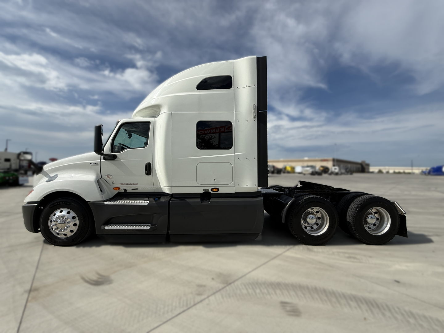 Truck side view showing 2022 International LT625 conventional sleeper tractor with white cab and black lower panels.
