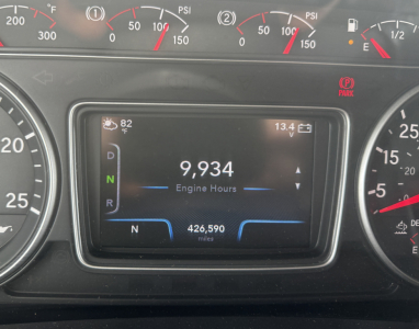 Dashboard center display showing engine hours 9,934 and N gear indicator with N 426,590 miles, 82°F outside, 13.4V, in International LT625 truck cockpit.