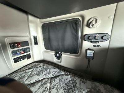 Interior sleeper cab panel with storage pouch, window shade, control switches, and power outlet visible in a 2022 International LT625 truck.