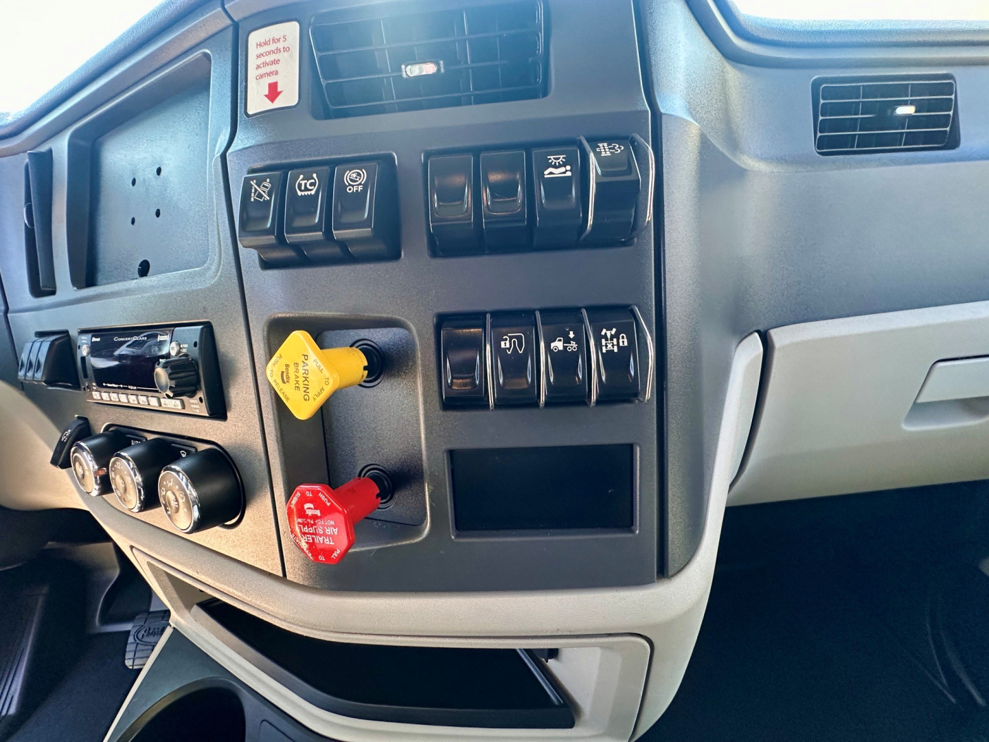 Peterbilt 579 dash cluster showing control switches, ignition, and dashboard compartments.