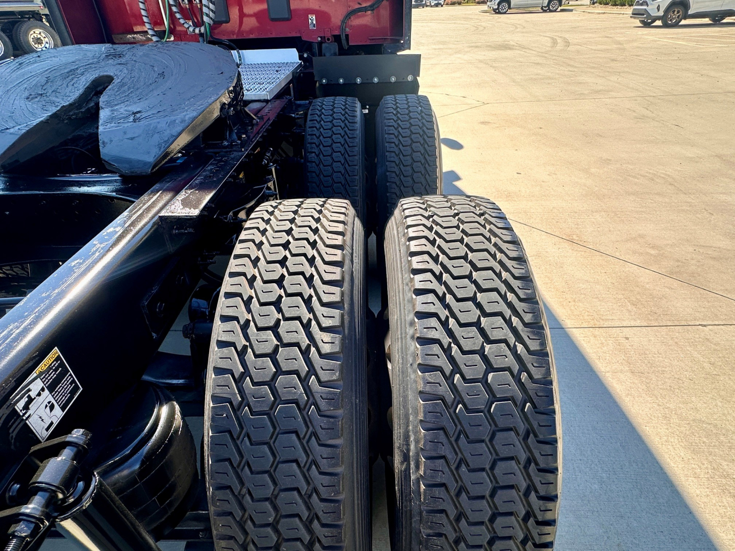 Peterbilt 579 chassis showing dual rear bogie tires and trailer connection area with metal framing and hydraulic component.