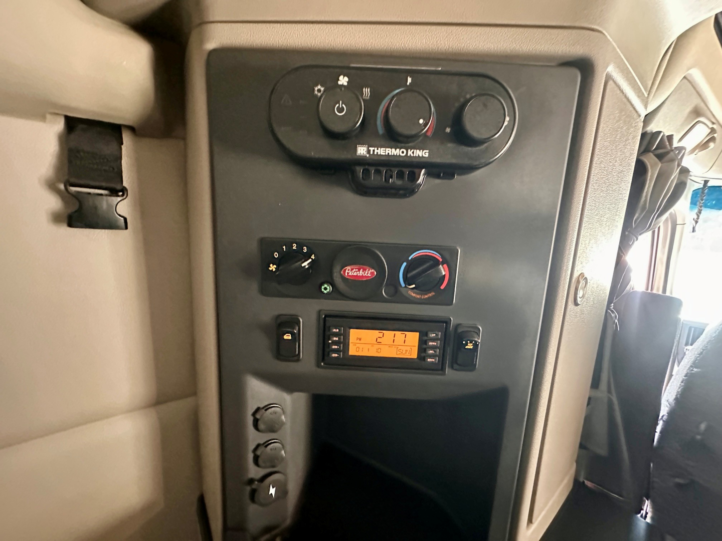 Peterbilt 579 cab interior showing climate controls, Thermo King unit, and digital display panel in dash area.
