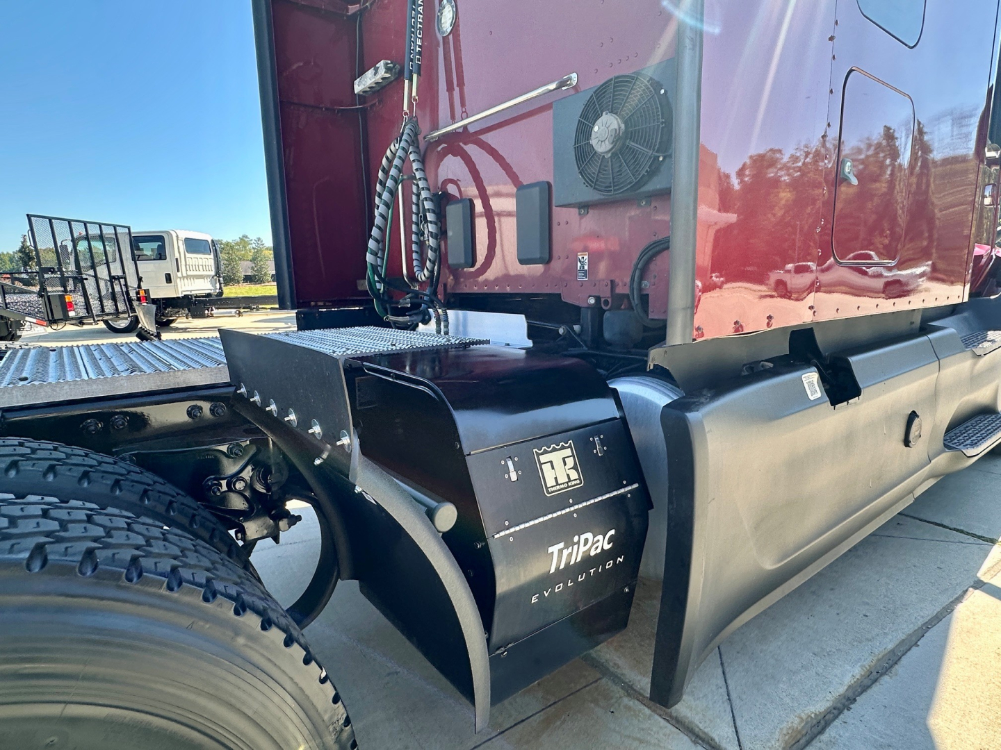 Peterbilt 579 engine bay area showing TriPac evolution A/C unit and rear sleeper panel with hoses and cables.