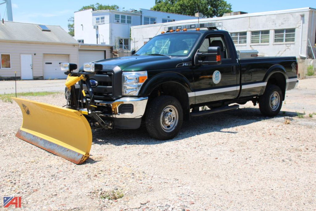 Ford F-250 Super Duty pickup with front plow, black crew cab, side view showing plow attachment.