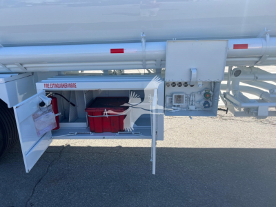 Tank trailer side compartments with an exposed red toolbox and control panel visible.