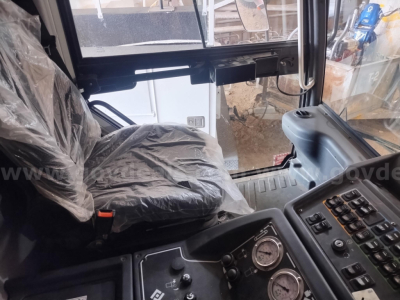 Cab interior of a used Elgin 6000 sweeper showing driver's seat with plastic cover and instrument cluster with gauges and controls.