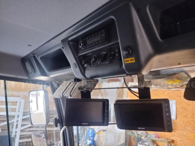 Elgin 6000 sweeper truck cabin dashboard with two mounted screens and control panel; upside-down view showing instrument cluster and dashboard electronics.