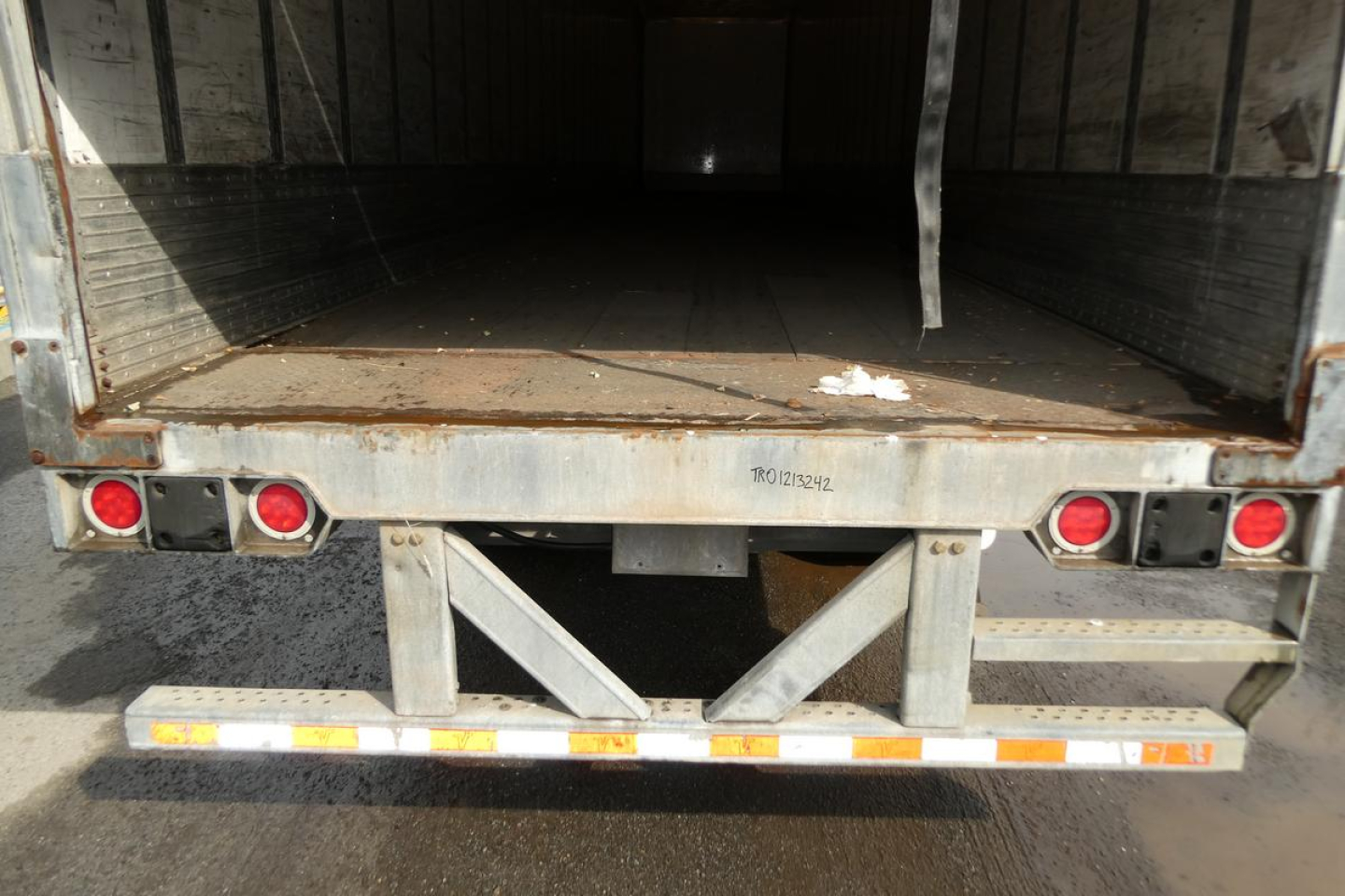 Rear of Vanguard VXP trailer showing open cargo area, rear bumper with lights, and a ramp-like frame. There is stamped or etched text on the frame: 'ROY...?' and a few small labels.