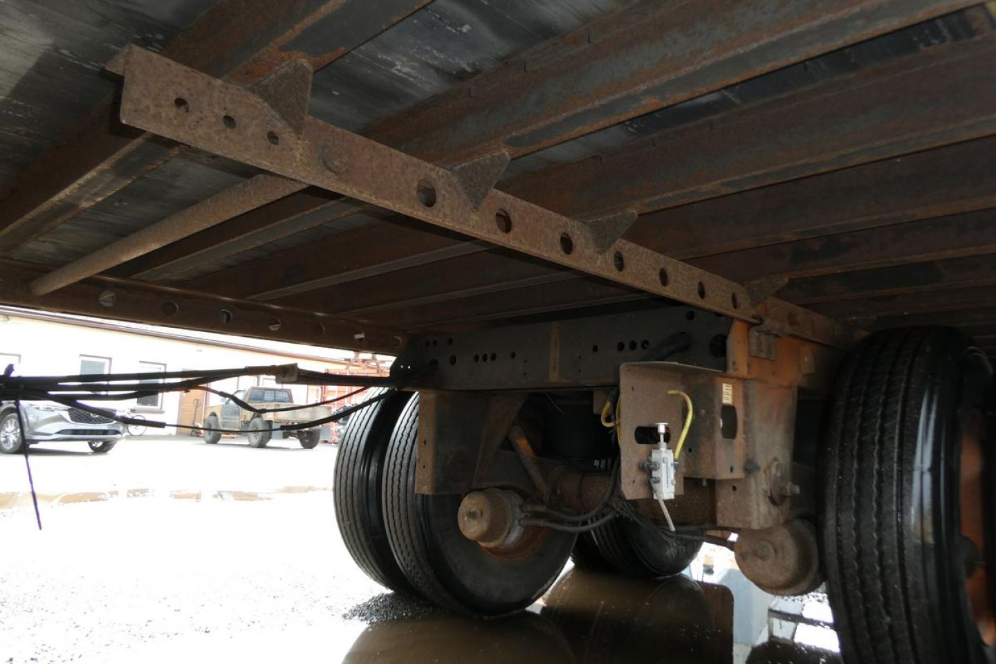 Underneath view of Vanguard VXP trailer chassis showing axles and frame with riveted I-beam and bolt connections.