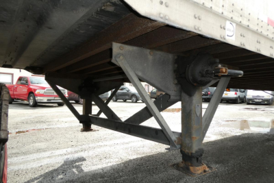 Trailer undercarriage showing support legs and frame cross members.