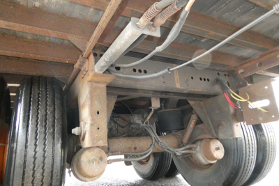 Trailer axle assembly and undercarriage of Vanguard VXP showing dual wheel setup, leaf springs, and frame with wiring, with visible bolts and rust-free components.