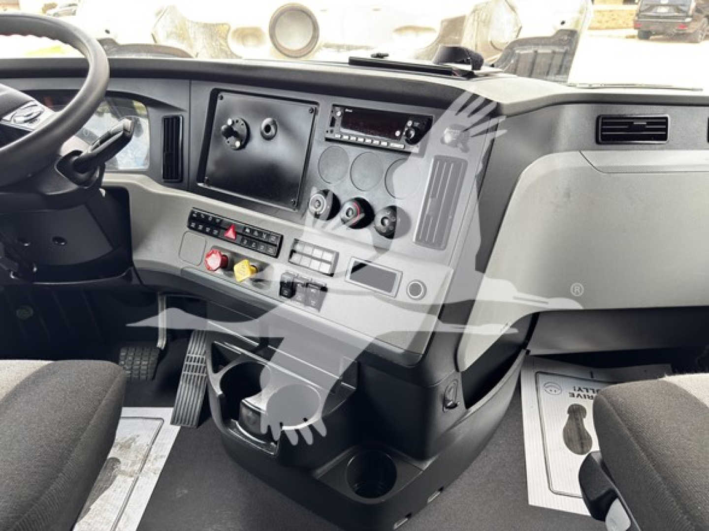 Dashboard view of a 2022 Freightliner Cascadia 126 sleeper. Visible components include steering wheel, instrument panel with gauges, center console with switches, cupholders, and pedal area.