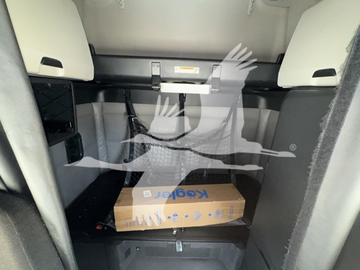 Cab interior showing a cardboard package in the lower bunk shelf of a 2022 Freightliner Cascadia 126 sleeper truck.