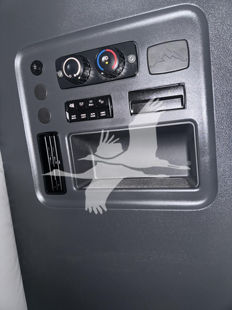 Truck interior panel showing climate controls and small storage pocket from Freightliner Cascadia dash area.