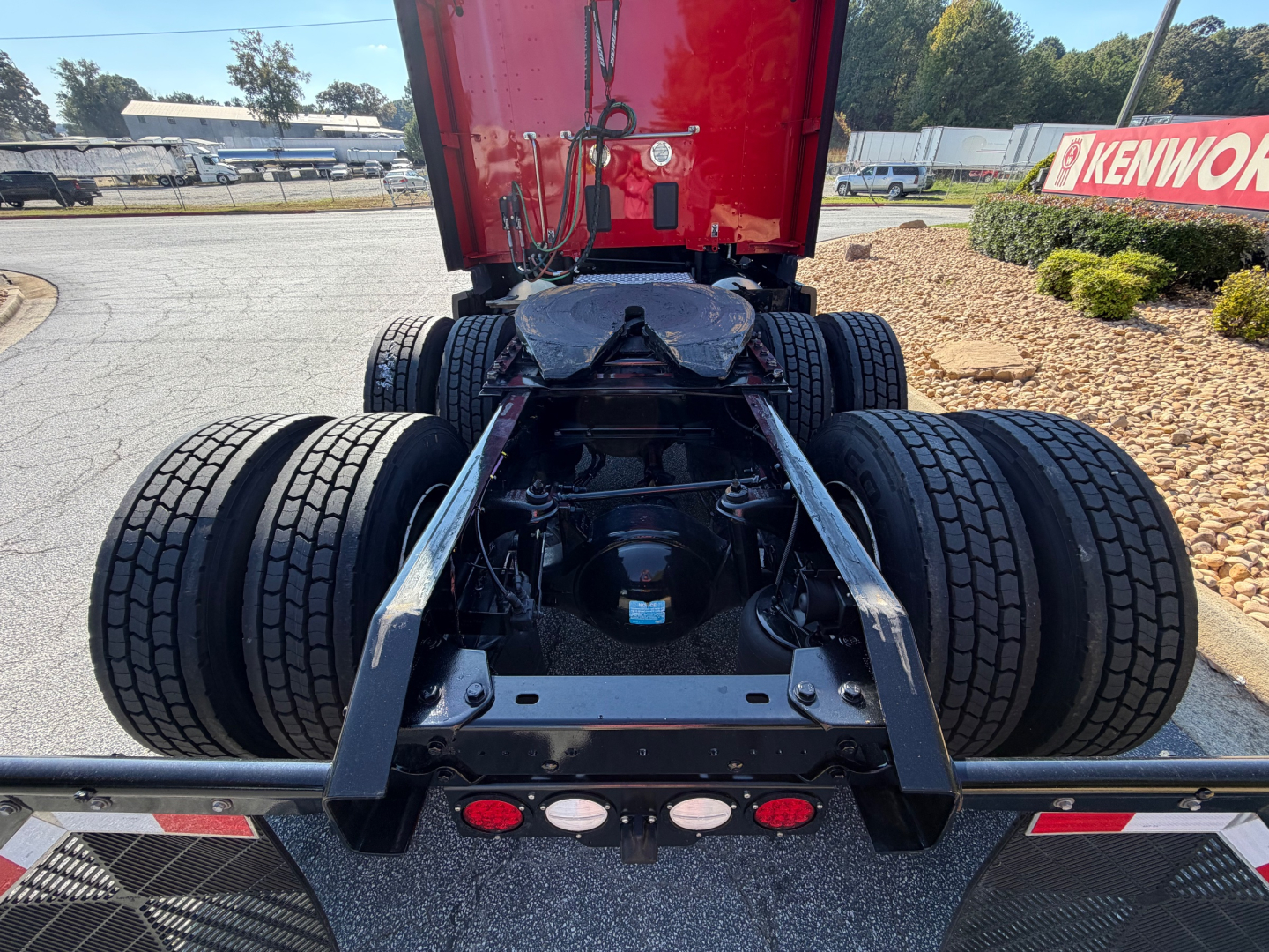 Kenworth T680 chassis with dual rear axles and fifth wheel, view from rear showing drivetrain and suspension components.
