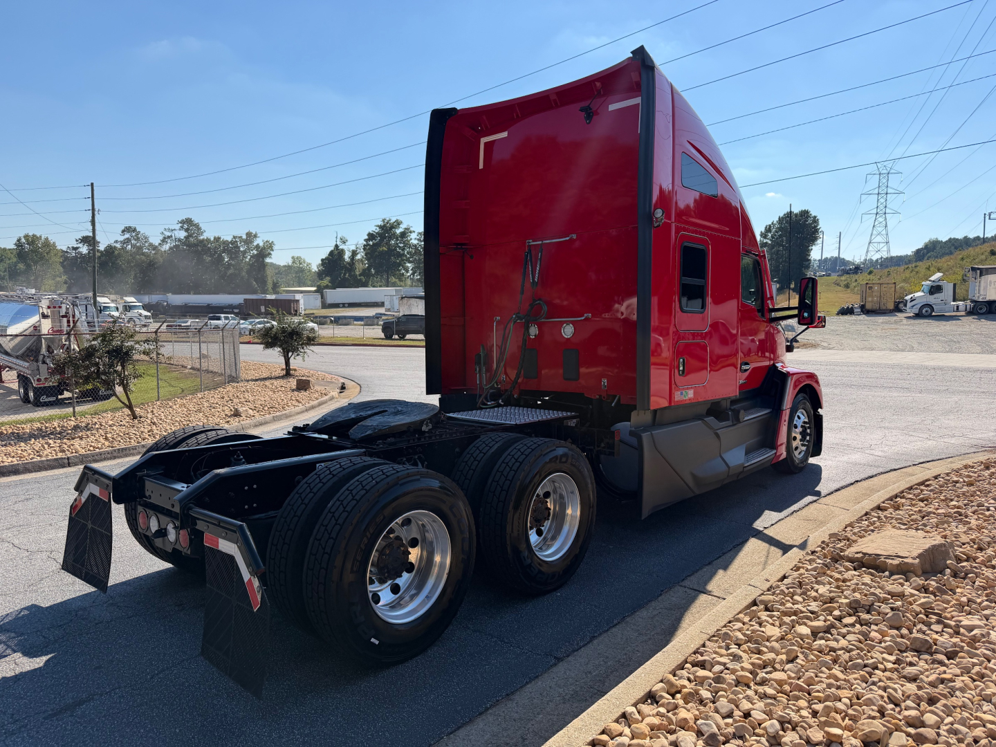 Kenworth T680 exterior rear three-quarter view showing dual rear wheels and red sleeper cab.