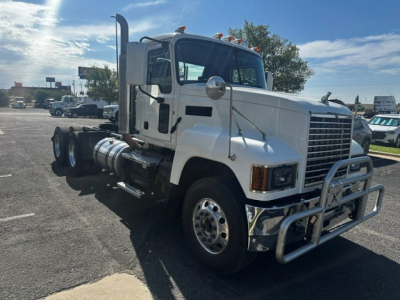 Truck cab showing front grille with chrome bumper guard and large side mirrors. Visible are two orange clearance lights on roof, bumper guard, and side steps.
