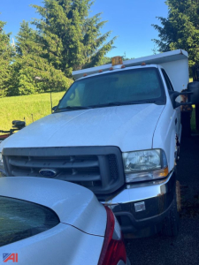 Ford F-450 dump truck in-service shown from front-right angle with amber beacon lights and dump body visible.