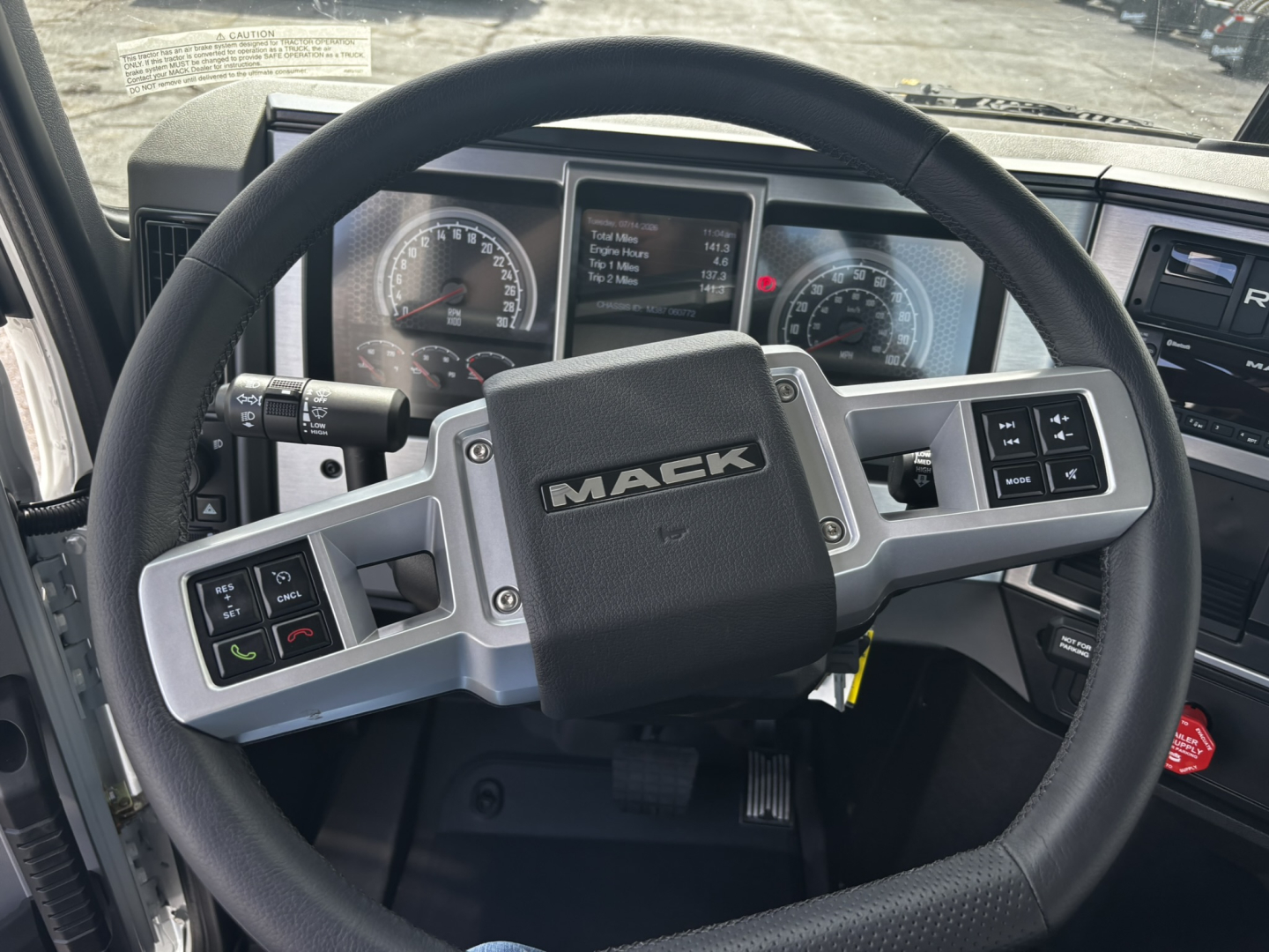 Mack GR64FT steering wheel and dash view showing ergonomic center display and control buttons.