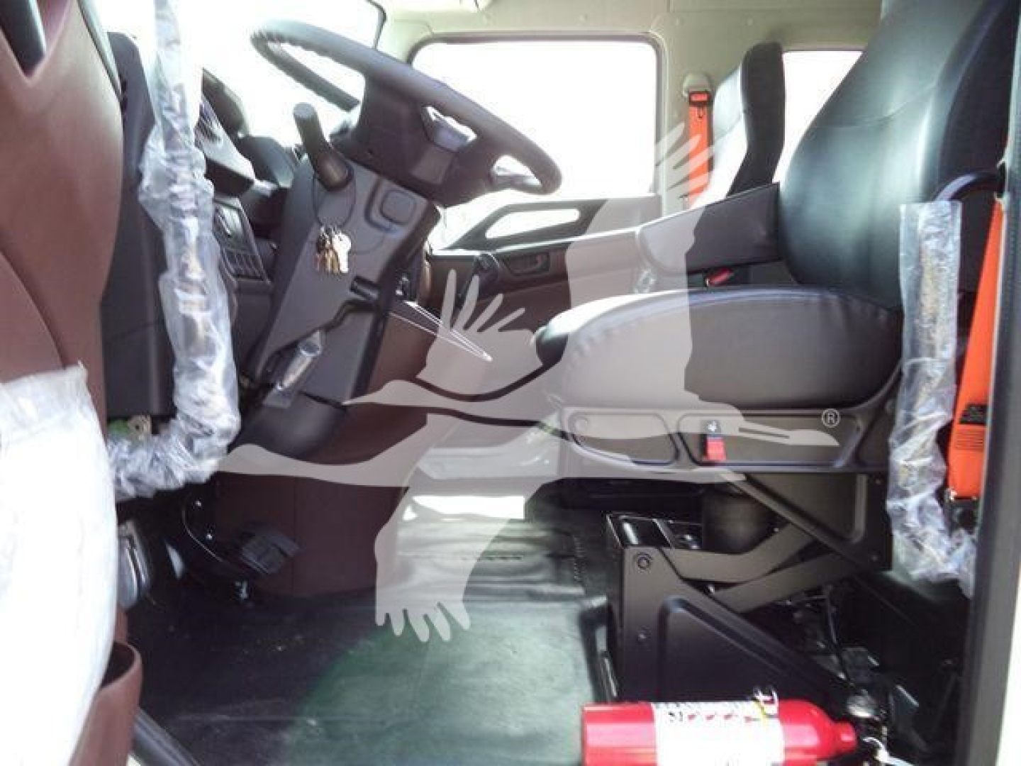 Truck cab interior of a 2026 Hino L6 showing steering wheel, driver's seat, and dashboard.