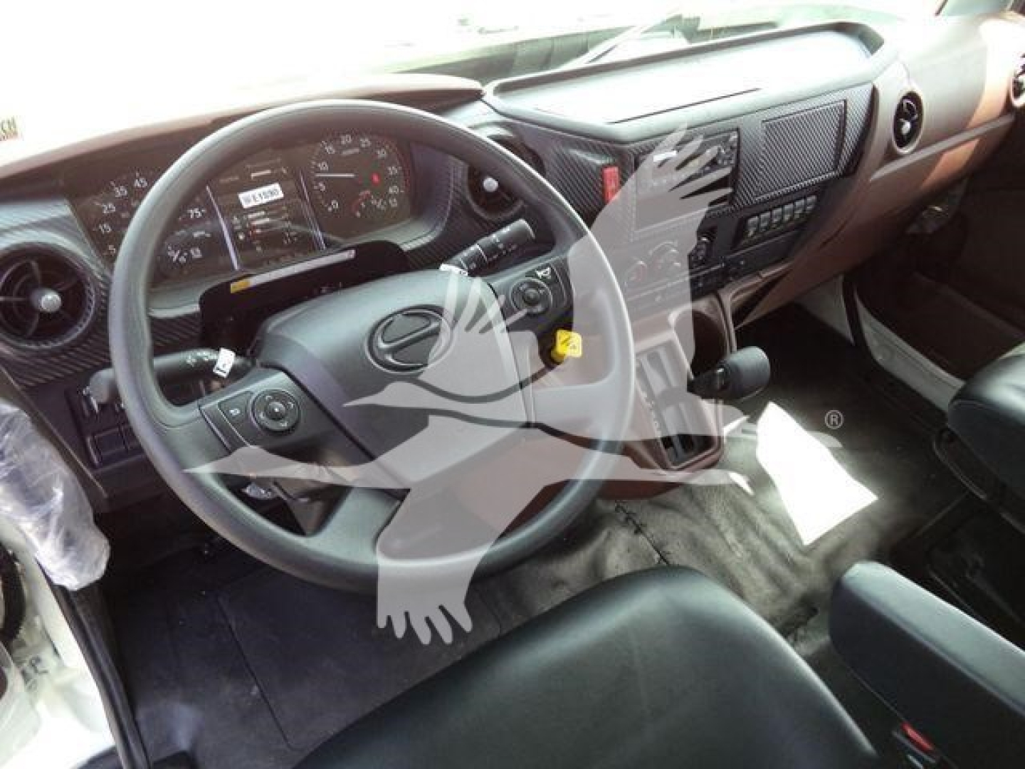 Truck cab interior showing steering wheel and dashboard of a 2026 Hino L6 rollback truck.