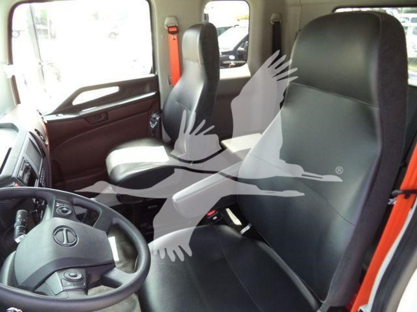 Interior of a new 2026 Hino L6 rollback truck showing driver seat and passenger seat with steering wheel and dashboard visible.