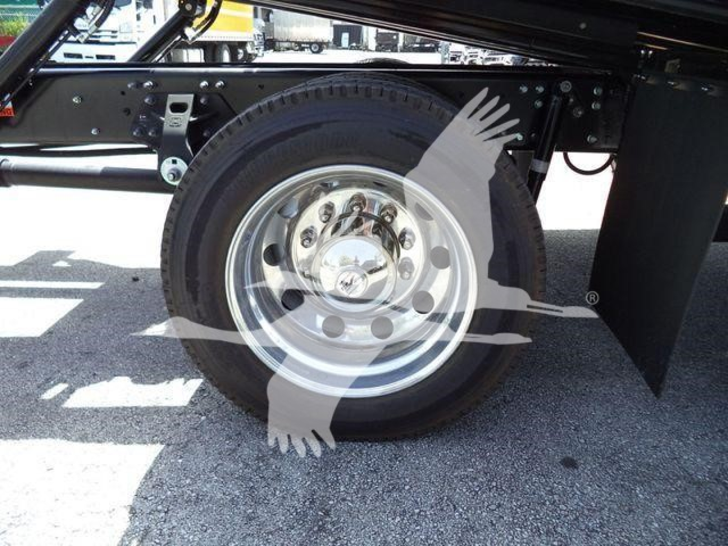 Wheel and tire assembly of a 2026 Hino L6 rollback truck showing front wheel with hub and nearby frame components.