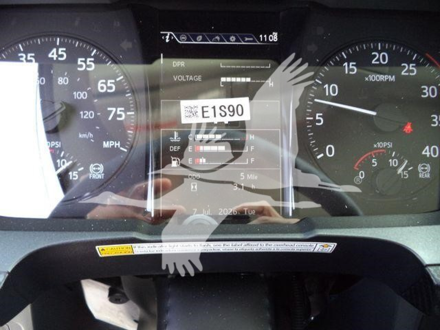 Dashboard display showing E15S90 voltage/readout label and instrument cluster with speedometer and tachometer