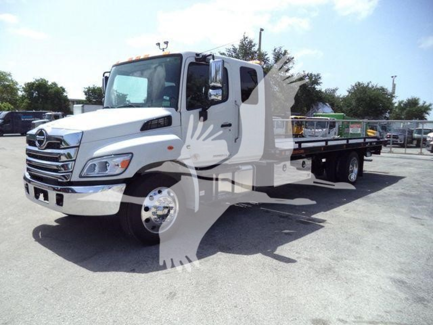 Hino L6 rollback truck in a lot with white cab and flatbed, VIN 5PVNJ7ET5T5T50066.