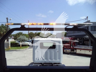 Back view of a 2026 Hino L6 rollback truck showing rear cab window and a rooftop warning light bar.