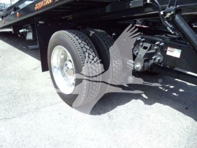 Truck chassis with dual rear wheels and undercarriage components visible, including suspension and mountings.