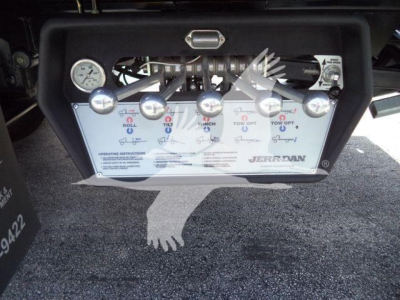 Control panel with levers and gauges on a compact rescue or rollback truck, showing labeled switches and a white panel with instructions and brand label JERR-DAN.
