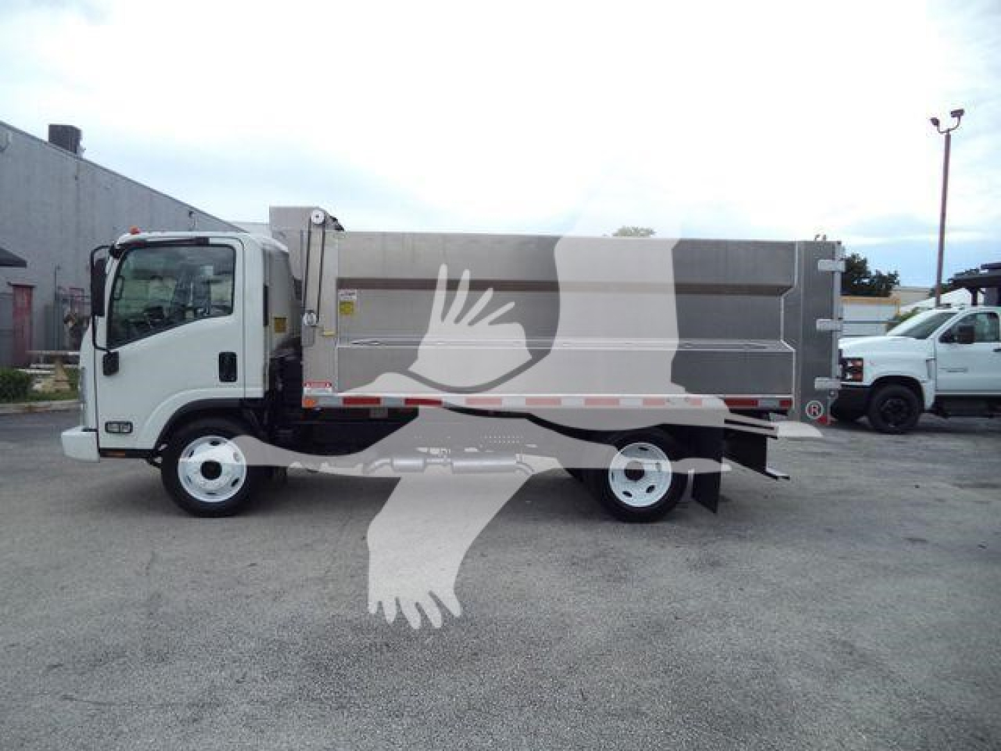 Chevrolet W4500 dump truck side view showing cargo bed and cab with white and gray color scheme.