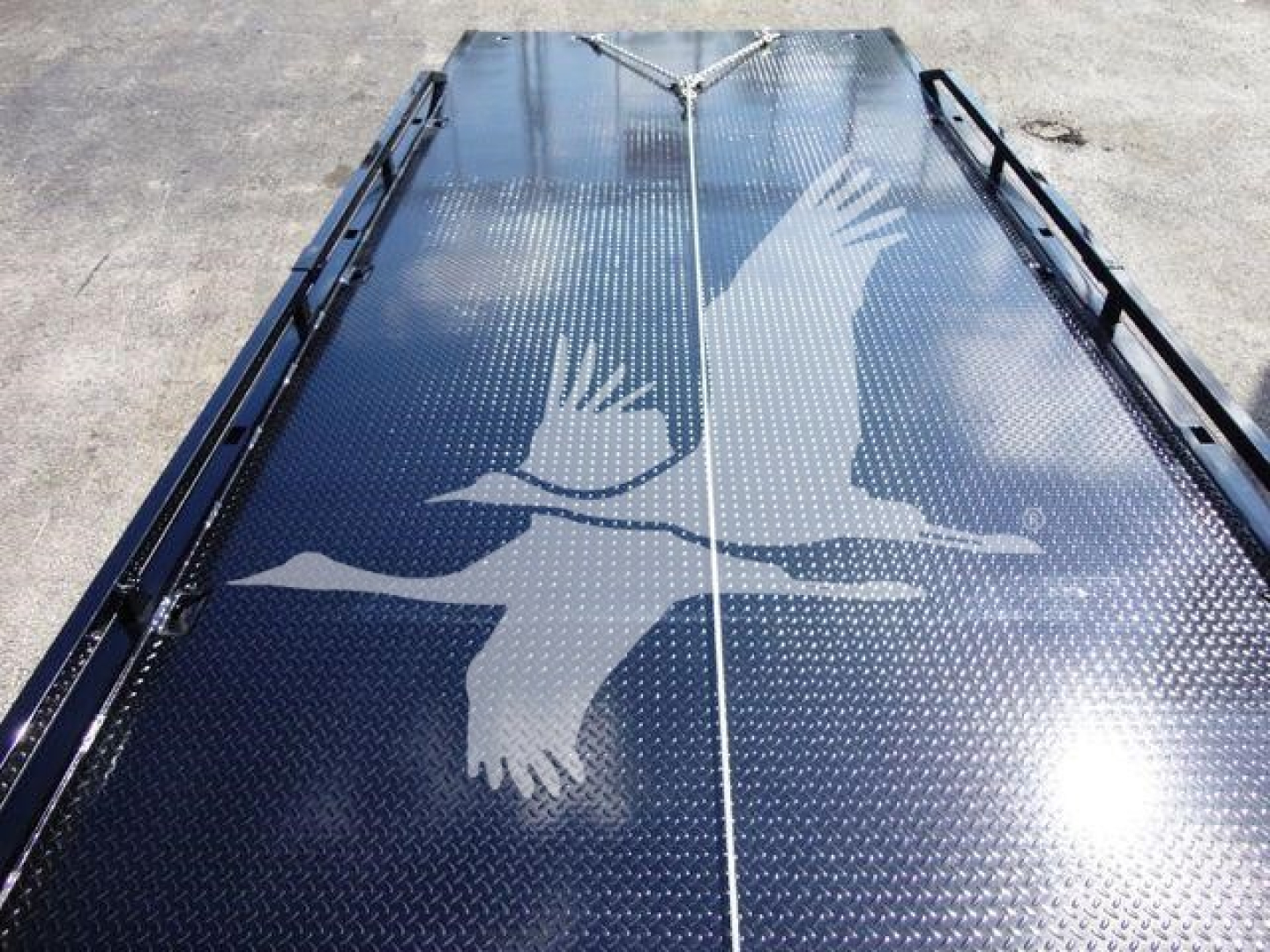 New 2026 Mack MD6 rollback truck bed shown with diamond plate surface and white bird graphic.