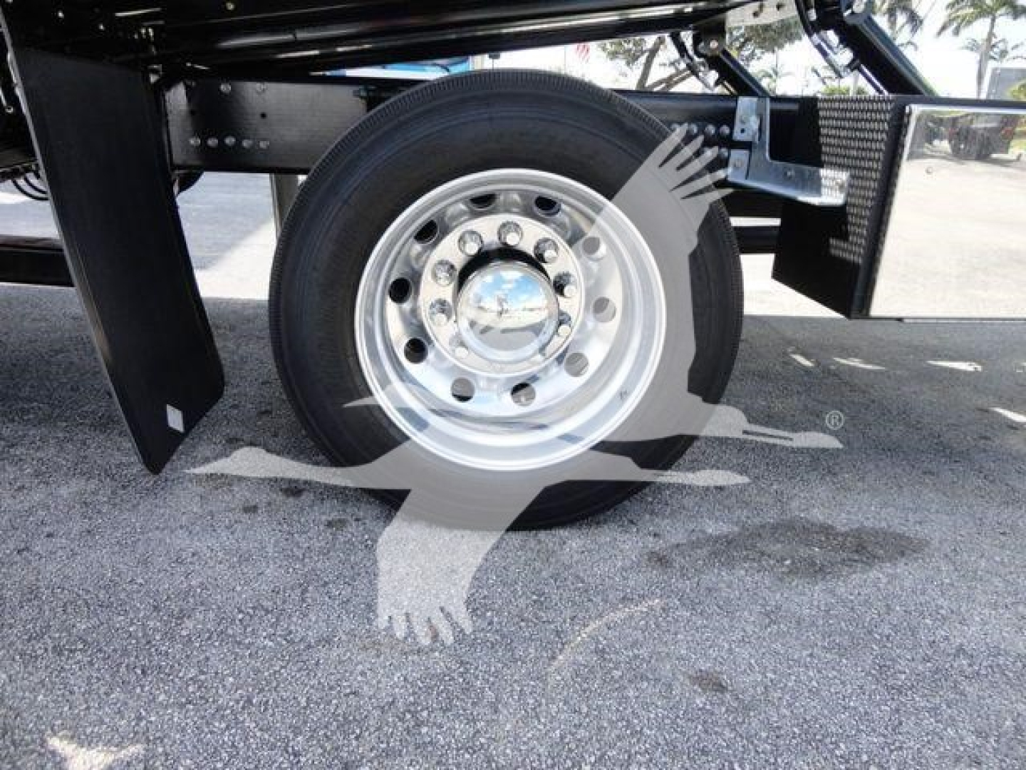 Wheel and suspension area of a 2026 Mack MD6 rollback truck showing front wheel with chrome hub and surrounding chassis components.