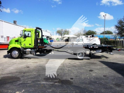 Green Mack MD6 rollback truck with flatbed and tow equipment, side view, stock number J04366.