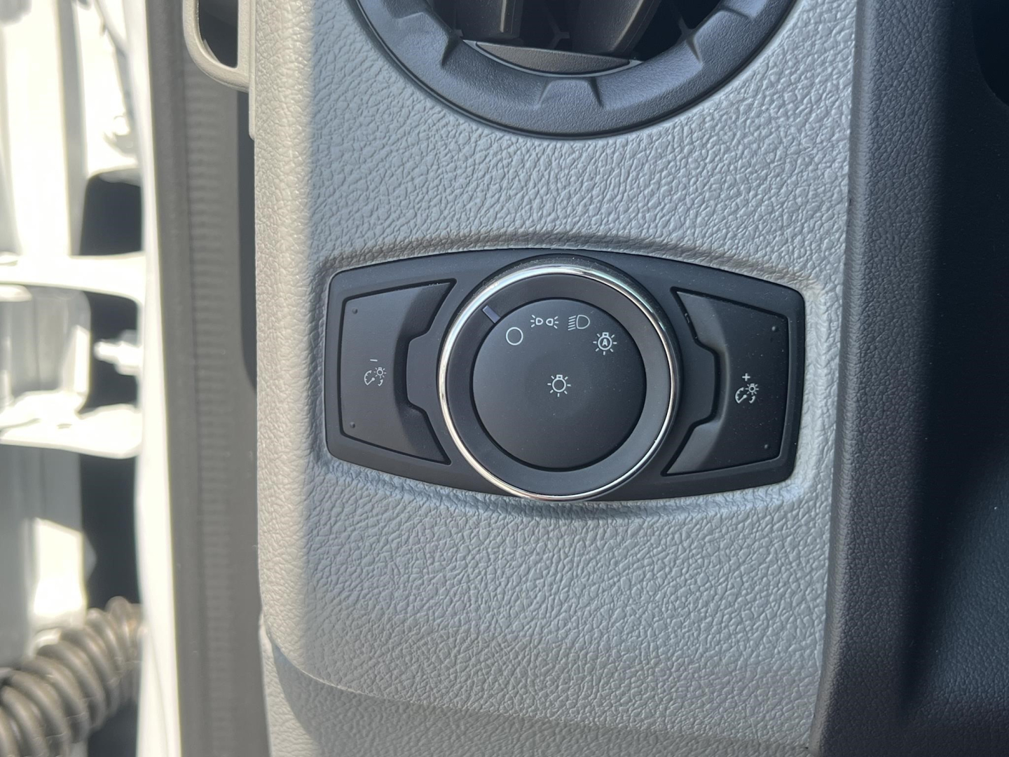 Ford E-Series van/utility truck headlight switch panel visible with circular dial and two side buttons.