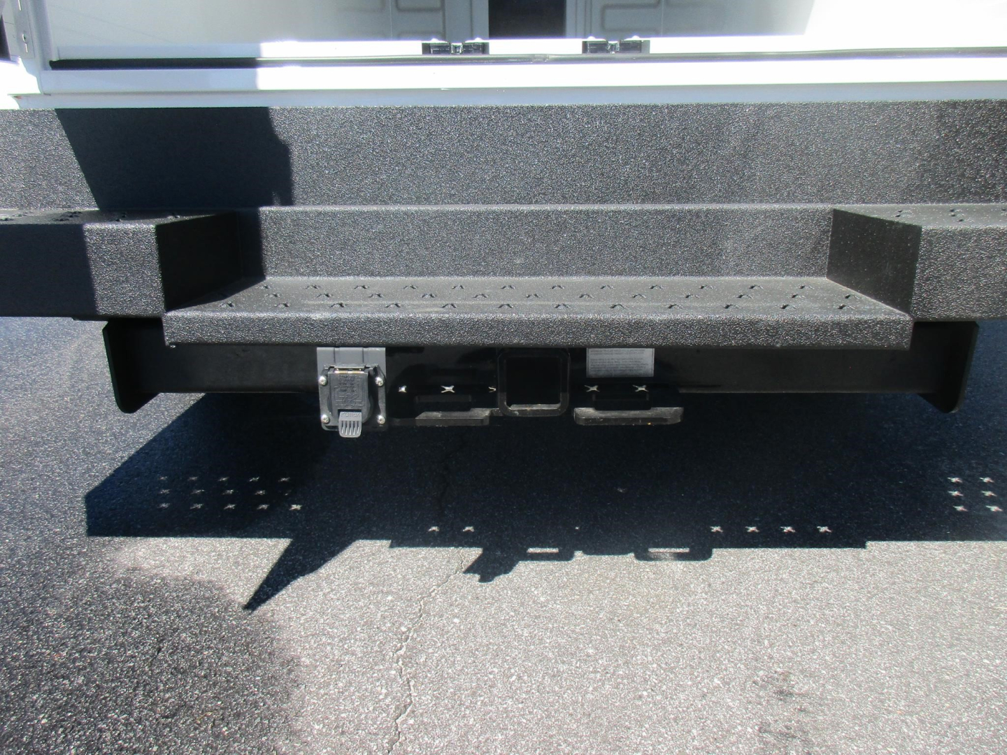 Ford E-350 service/utility truck rear view showing hitch receiver and bumper.