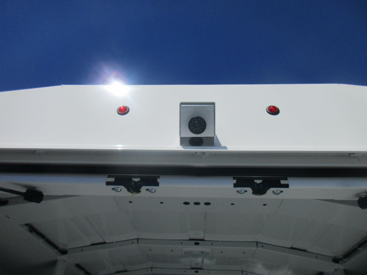 Ford E-350 cargo area rear view showing rear doors and underbody, with wiring and structural cross members visible.