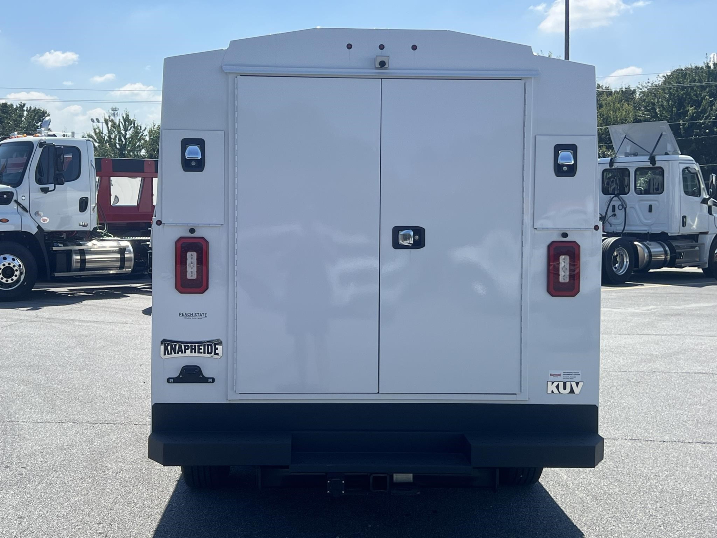 Ford E-Series service/utility box truck rear view showing double doors, tail lights, bumper, and VIN plate area.