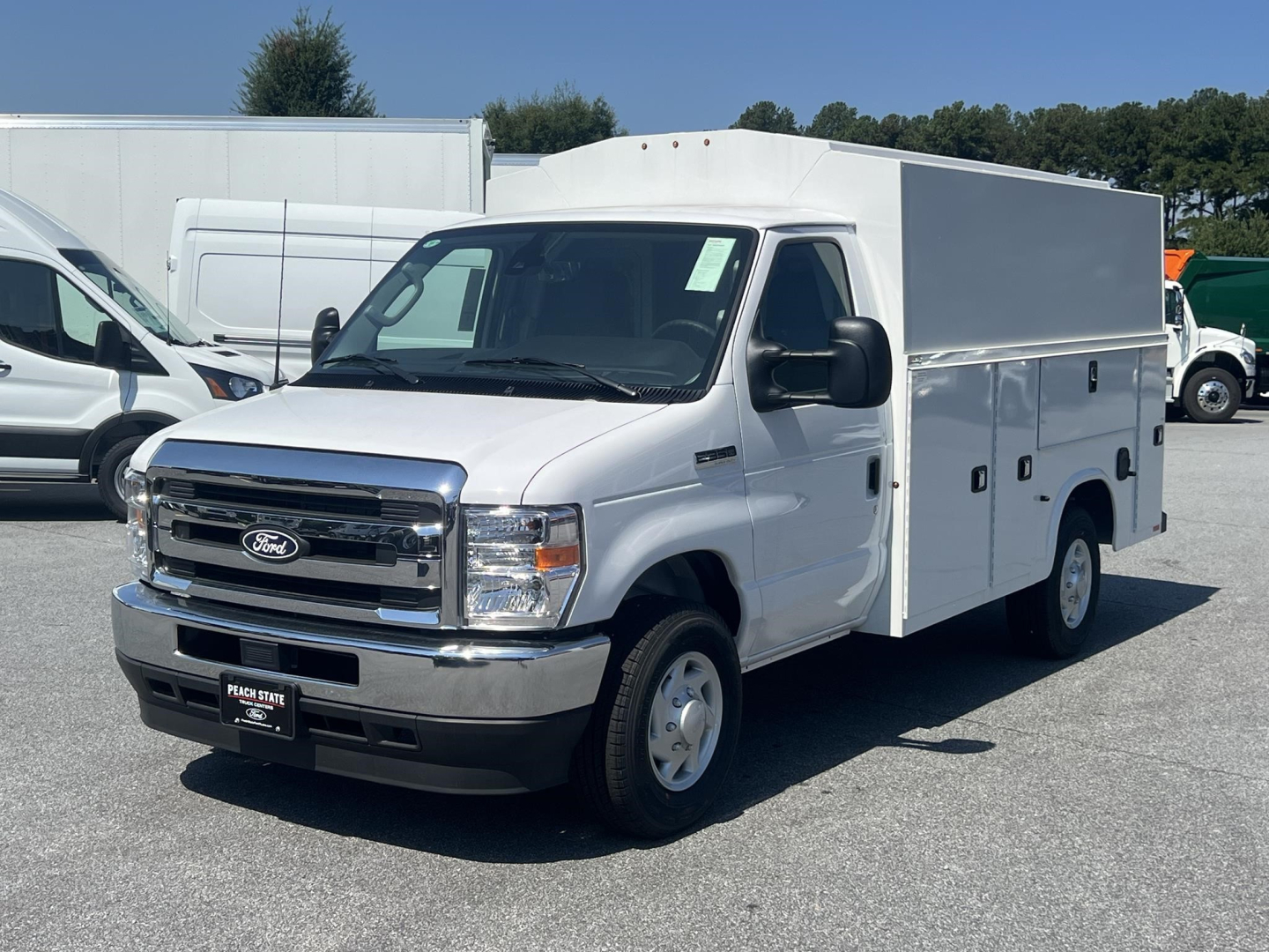 White Ford E-350 service utility van with box cargo area, front grille and headlights visible, VIN 1FDWE3FN3TDD36007 on dealer plate.