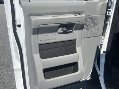 Ford E-Series door panel with storage pockets and speaker grille visible in the open driver door.