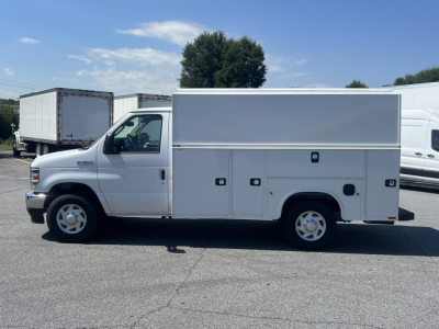 Ford E-350 service utility van side view with multiple storage compartments and toolbox doors visible.