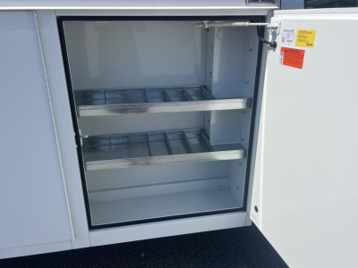 Ford E-Series Utility van rear storage cabinet showing empty metal shelves inside cabinet with open white doors.