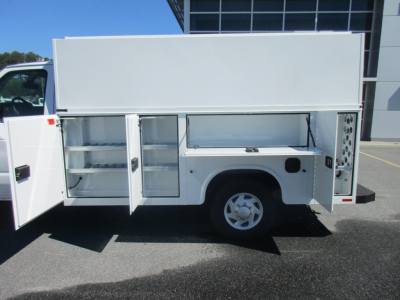  Ford E-350 service utility truck side view showing multiple storage compartments with open doors and cargo drawers.