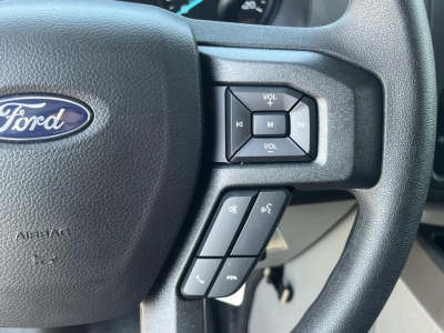 Ford steering wheel with control buttons; visible are volume controls, mode button, and phone/voice controls on the right side of the wheel