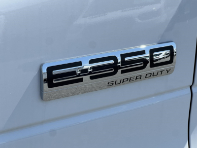 Ford E-350 Super Duty badge on the side of a white van showing 'E-350' and 'SUPER DUTY' text.