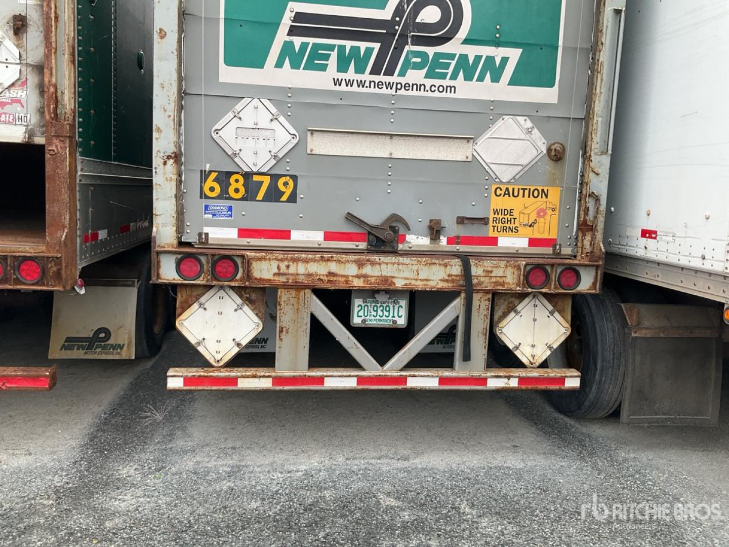 Back of a New Penn trailer with safety decals and license plate visible; VIN 1JJV452W23L829297 and stock number 0531247 on the rear doors.